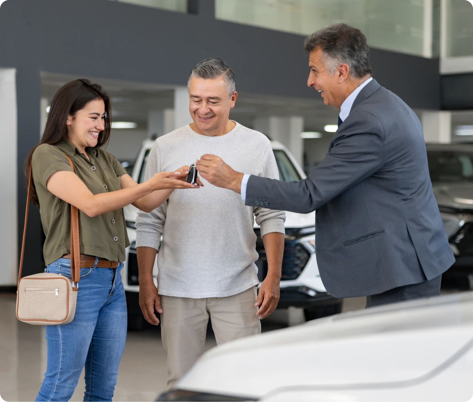 Car buyer receiving keys from salesman